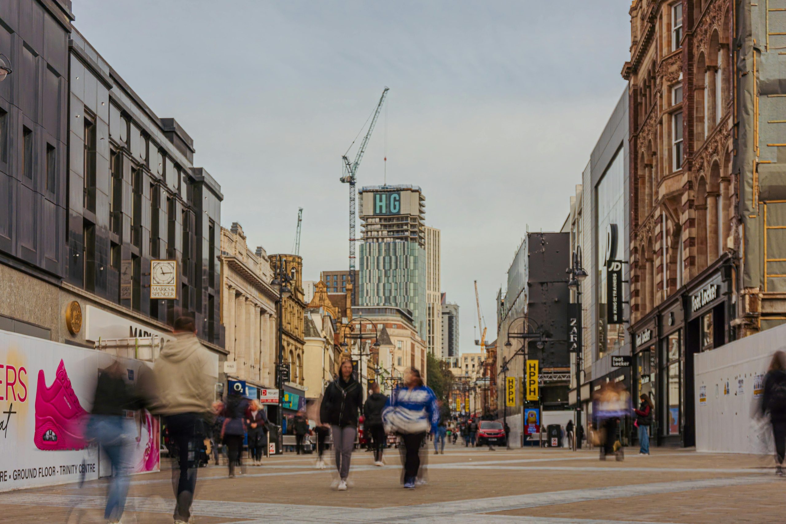 Bustling pedestrian street in downtown Leeds, UK, capturing the urban architecture and city life.