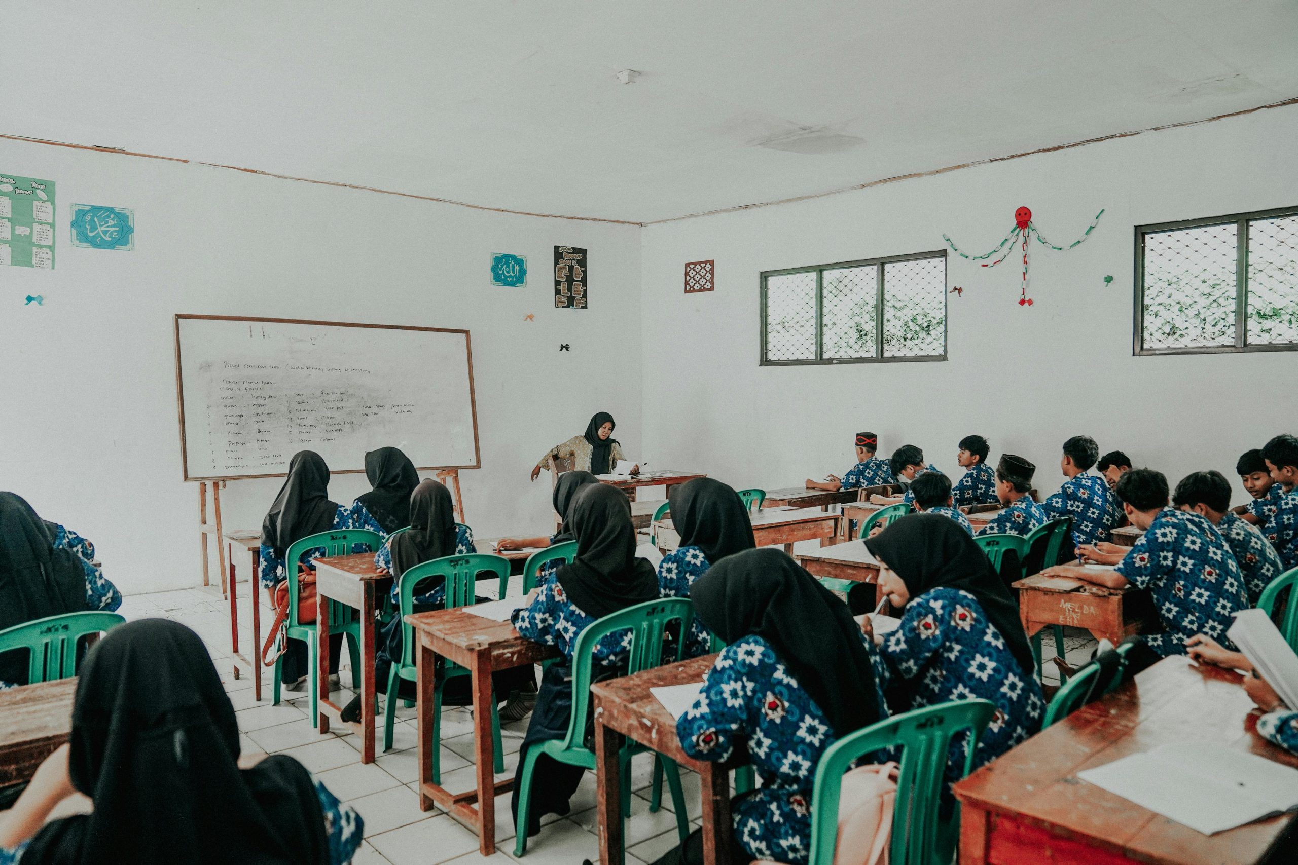 Students in traditional attire attend a lesson in a Pandeglang classroom.
