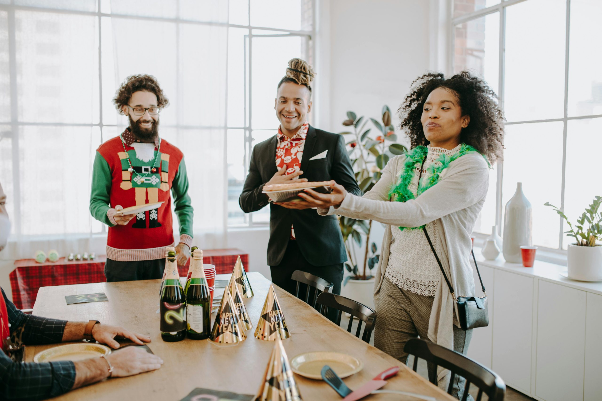 Diverse coworkers enjoy a festive office party with food, drinks, and cheerful decorations.