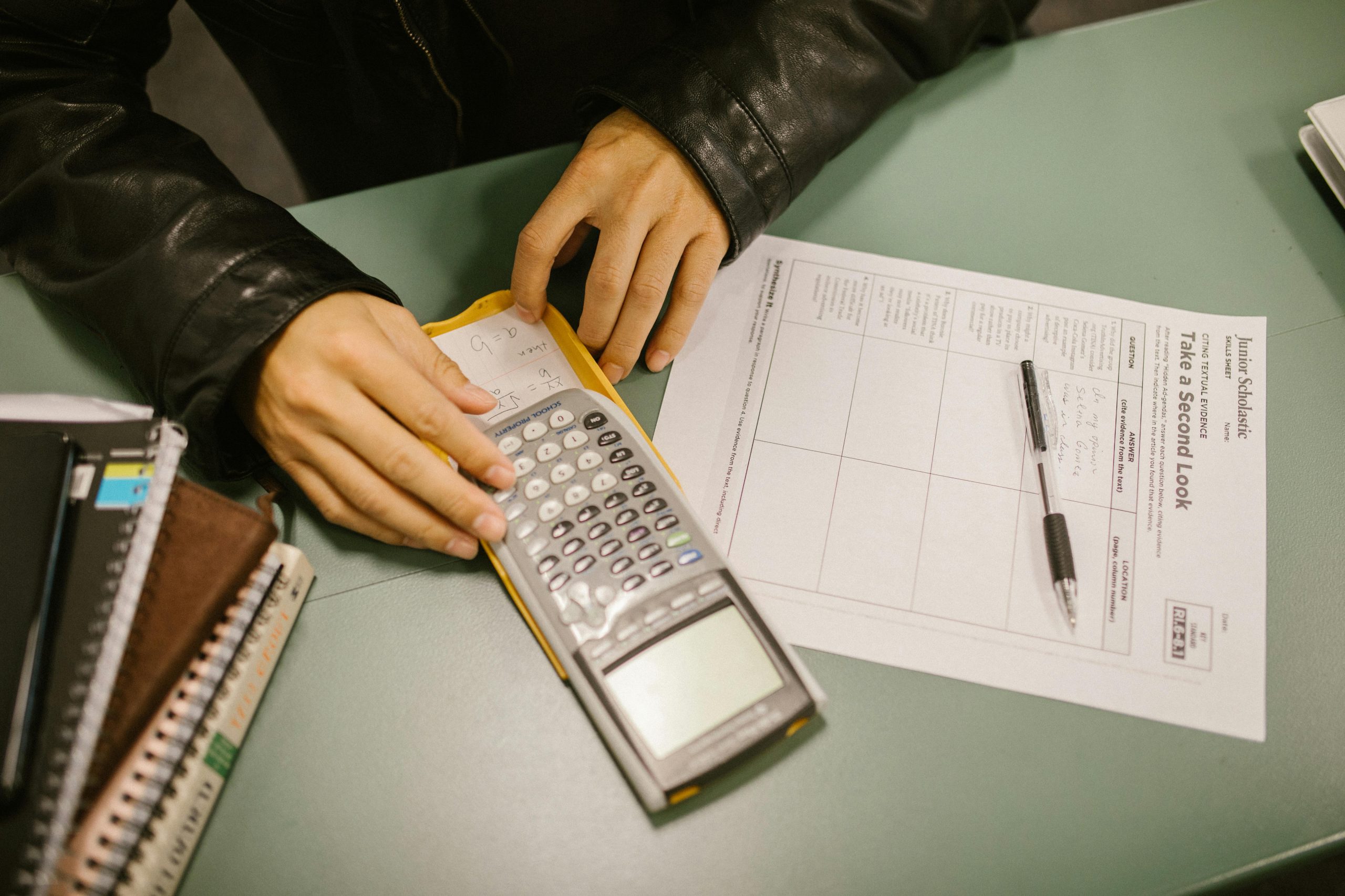A student covertly uses a cheat sheet hidden in a calculator during an exam.